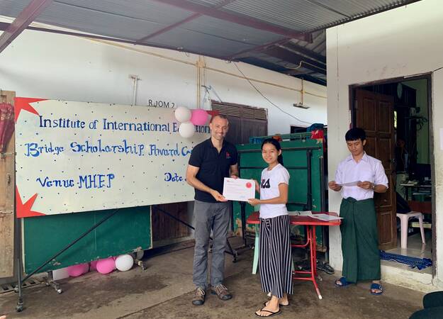 Jonathan Lembright presents award to displaced student at Mae Sot