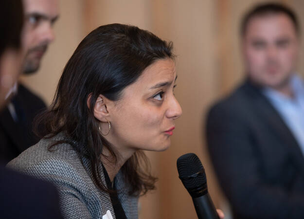 Speaker leaning into a mic to speak at the IIE PEER Forum 2019