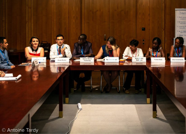 Ehab sits in a UNHCR panel presentation. 